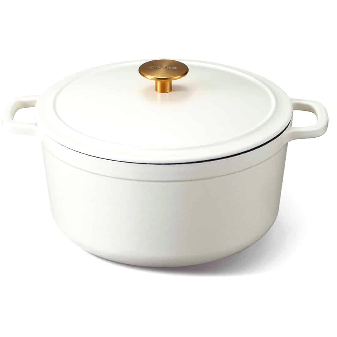 White enameled cast iron Dutch oven with two side handles and a gold knob on the lid, placed on a white background—the perfect vessel featured in the ultimate homemade bread guide.