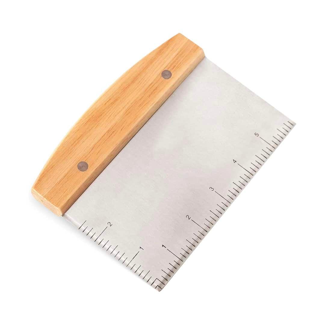 A metal dough scraper with a wooden handle and measurement markings along the bottom edge—an essential tool for anyone following the ultimate homemade bread guide.